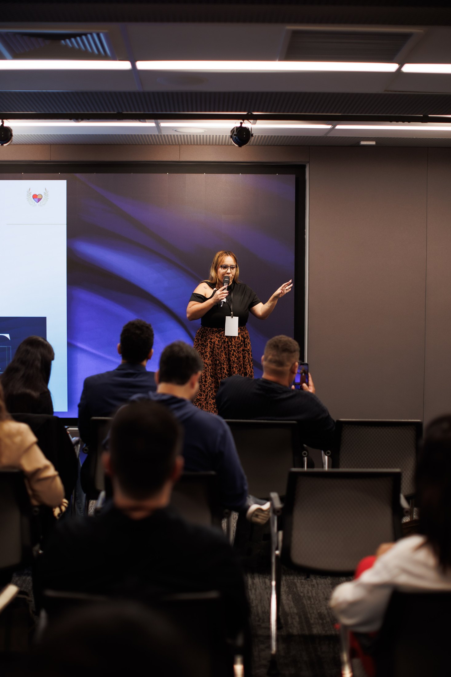 Julie Anie falando para uma audiência em evento corporativo